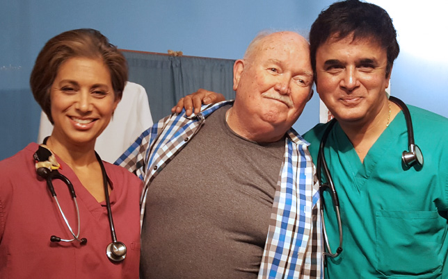 Medical assistant with older patient smiling with doctor Massil