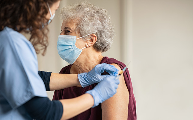older lady about to receive a shot on her arm